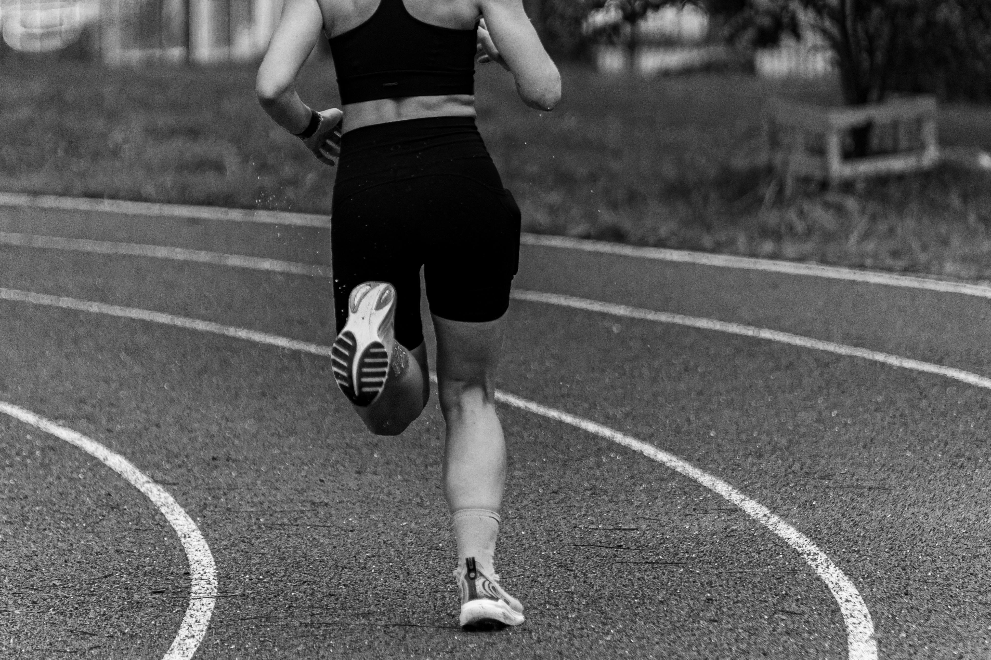 Runner sprinting on a track, photographed from behind