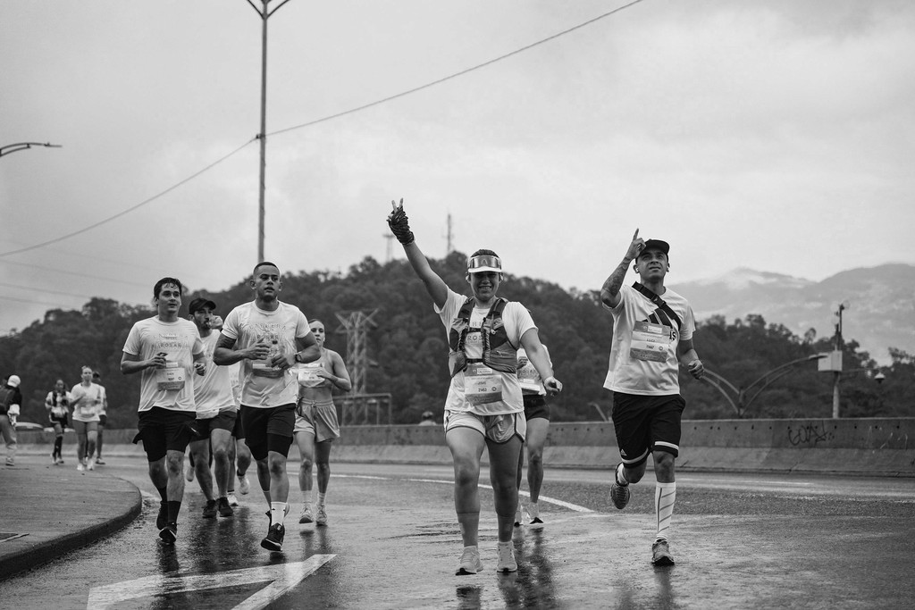 Group of marathon runners celebrating on a rainy road race